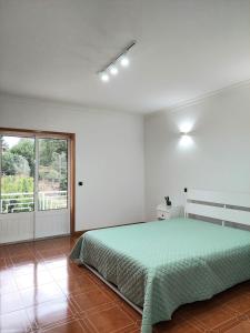 a bedroom with a bed and a large window at CANAVESES RIVER HOUSE - ALOJAMENTO RURAL in Marco de Canaveses