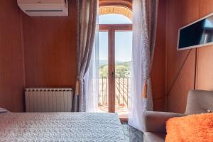 Schlafzimmer mit einem Bett und einem Fenster mit einem Balkon in der Unterkunft Cassola Del Priorat in Gratallops