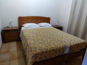 um quarto com uma cama e duas mesas de cabeceira com dois candeeiros em Casas de Santo António - A em Odeceixe