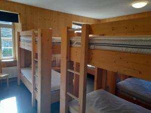a room with three bunk beds in a cabin at Ostello Santa Maria 6541 Santa Maria in Santa Maria