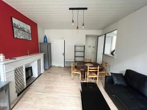 Ti Feunteun Pontrev في Pontrieux: غرفة معيشة مع أريكة سوداء وطاولة