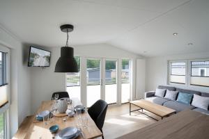 ein Wohnzimmer mit einem Tisch und einem Sofa in der Unterkunft Ferienhaus "TO HUUS" mit kostenfreier Saunanutzung in Scharbeutz