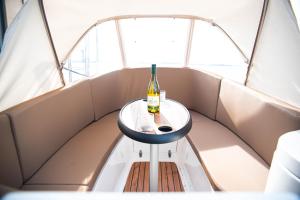 a bottle of wine sitting on a table in a boat at Maasbootje in Kinrooi