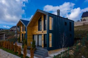 een huis met een zwarte en houten buitenkant bij Vista Durmitor - luxury cabin in Žabljak