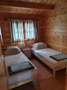 a room with two beds in a log cabin at Leśniczówka-Wdzydze Pe eL in Wdzydze Kiszewskie