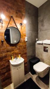 a bathroom with a sink and a toilet and a mirror at Apartament Polaniczanka in Polanica-Zdrój