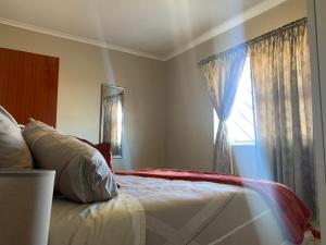 a bedroom with a bed and a window at manu'z in Cape Town