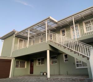une maison verte avec un balcon au-dessus dans l'établissement manu'z, au Cap