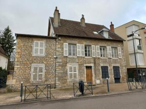 an old brick house with white windows on a street at Le Montjoux, appartement calme, toutes commodités in Besançon