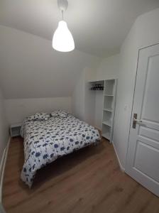 a white bedroom with a bed and a white door at Le Montjoux, appartement calme, toutes commodités in Besançon