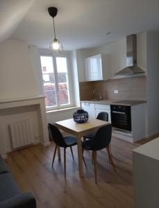 a kitchen with a table and chairs in a room at Le Montjoux, appartement calme, toutes commodités in Besançon