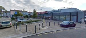 a parking lot with cars parked in front of a store at Le Montjoux, appartement calme, toutes commodités in Besançon +4 photos