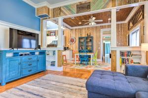 a living room with a blue couch and a tv at Cottage with Porch - 3 Min Walk to Bay St Louis in Bay Saint Louis