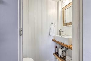 a bathroom with a white sink and a mirror at Cottage with Porch - 3 Min Walk to Bay St Louis in Bay Saint Louis +27 photos