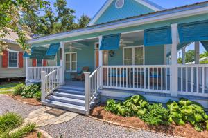 a blue house with a porch with blue shutters at Cottage with Porch - 3 Min Walk to Bay St Louis in Bay Saint Louis