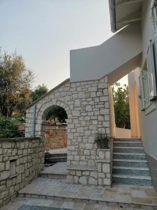 a stone building with stairs and an archway at Perithia Cottage in Perítheia