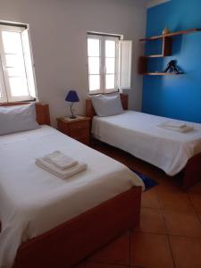 dwa łóżka w pokoju z dwoma oknami w obiekcie T2,Casa Sol e Mar 50464/AL w mieście Vila Nova de Milfontes