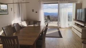 a dining room with a table and chairs and a television at Yellow House Grabrovec in Metlika