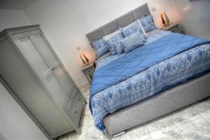 a bedroom with a bed with a blue comforter at Criccieth- STUDIO GLAN ERIN BACH in Criccieth