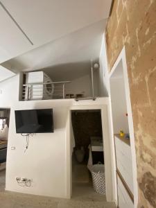 a room with a white wall with a tv on it at La Casetta in Altamura