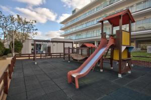 a playground with a slide in front of a building at Marina Club Lagos Resort in Lagos