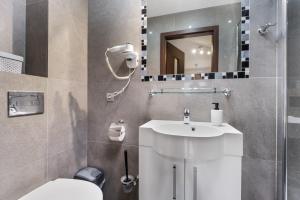 a bathroom with a sink and a toilet and a mirror at Villa Lordis in Krynica Morska +75 photos