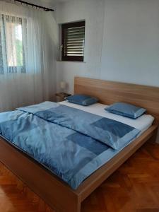 ein Schlafzimmer mit einem großen Bett mit blauer Bettwäsche in der Unterkunft Apartment Ivan in Vantačići