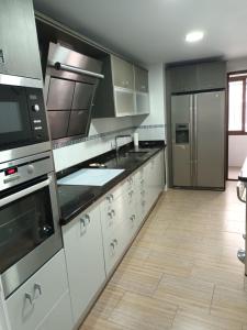 Il comprend une grande cuisine avec des placards blancs et un réfrigérateur. dans l'établissement Casa Coral, à Frigiliana