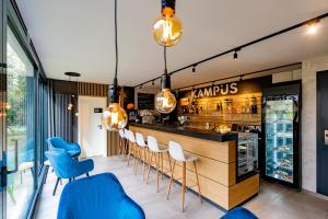 un bar en un restaurante con sillas azules en Apartments 4u: KAMPUS Upstairs Hradec Králové, en Hradec Králové