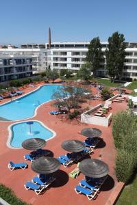 Elle offre une vue sur la piscine bordée de chaises et de parasols. dans l'établissement Marina Club Lagos Resort, à Lagos