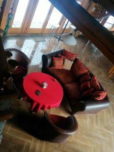 uma sala de estar com um sofá e uma mesa vermelha em Crossline Lodge em Gheorgheni