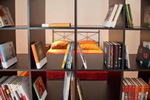 a book shelf filled with books and a bed at Apartment REZIDENCA GOGA in Novo Mesto
