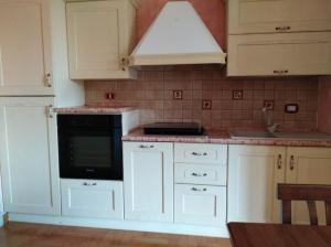 a kitchen with white cabinets and a black oven at La tavernetta a Trinitapoli in Trinitapoli