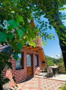 a brick house with a porch and a patio at Villat Parku i Liqenit in Orllan