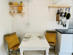 a white table in a kitchen with yellow chairs at Light Airy Detached Annex 2 Min Walk Train Station in Stowmarket