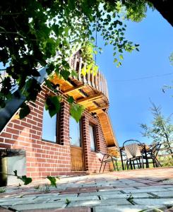 ein kleines Backsteinhaus mit einer Terrasse und einem Stuhl in der Unterkunft Villat Parku i Liqenit in Orllan