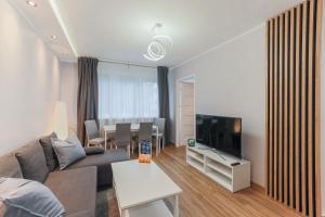 sala de estar con sofá, TV y mesa en AP Apartments Piastowska en Gdansk