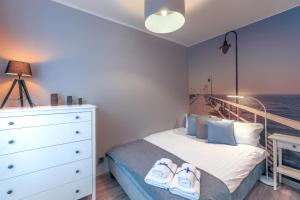 Un dormitorio con una cama y un tocador con zapatos. en AP Apartments Piastowska en Gdansk