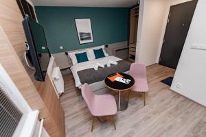 - une chambre avec un lit, une table et des chaises dans l'établissement Apartments 4u: KAMPUS Upstairs Hradec Králové, à Hradec Králové