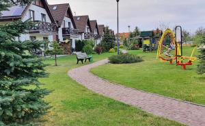 a park with a playground and a slide at Apartament Kalimera in Żarnowska