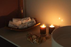 two candles and towels with writing on them on a table at Marina Club Lagos Resort in Lagos