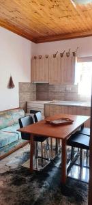 a kitchen with a wooden table and some chairs at VILLA PORTIANOU in Pedhinón +15 photos