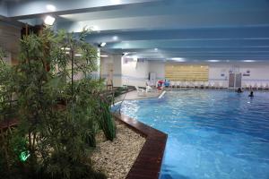 a large swimming pool in a hotel with people in it at Jerusalem Hotel Private Luxury Suites near Western Wall in Jerusalem