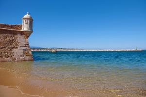 a lighthouse on the beach near the water at Marina Club Lagos Resort in Lagos
