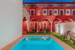 a courtyard with a swimming pool in a house at Hotel HO Merida in Mérida