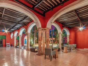 a large room with red walls and columns at Hotel HO Merida in Mérida
