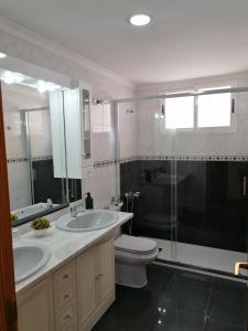 a bathroom with two sinks and a toilet and a shower at Apartamento mirador del Mar in Las Palmas de Gran Canaria