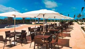 - une rangée de tables et de chaises avec parasols sur la terrasse dans l'établissement Salinas Park Resort, à Salinópolis