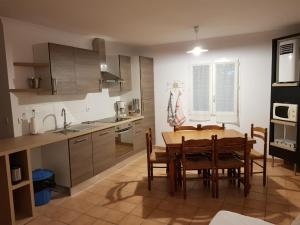 a kitchen with a wooden table and a dining room at Les Gîtes de l'Arbousier in Quissac +46 photos