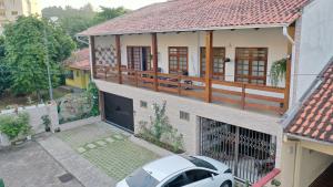 a house with a car parked in front of it at Pousada Central Jaraguá in Jaraguá do Sul